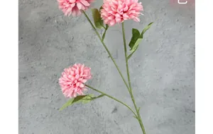 Detail of light pink artificial pompon chrysanthemum with three heads and green leaves