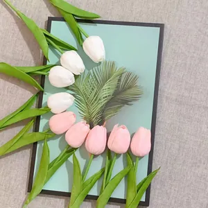 Ramo de tulipanes de PU rosas y blancos realistas con hojas sobre tablero decorativo