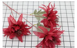 Vue détaillée de trois dahlias artificiels rouges avec pétales en soie et feuilles