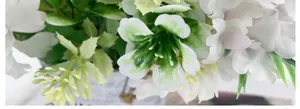 Close-up of white silk peony petals and green foliage in flower arrangement