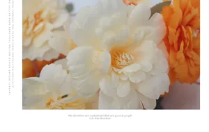 Gedetailleerde macro-opname van zijden kunstpioenen in crème en oranje met gele meeldraden
