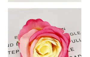 Dettaglio macro di testa di rosa artificiale con petali in seta sfumati rosa e giallo