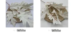 Macro detail of white artificial oak leaves with serrated edges on a woven mat