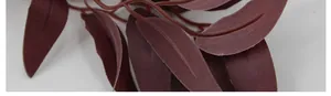 Macro shot of faux eucalyptus leaves showing realistic reddish-brown fabric texture