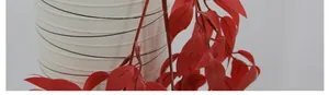 Détail de feuilles de saule artificielles rouges avec texture dans un vase en céramique