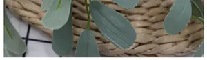 Macro shot of artificial green peanut leaves with textile texture on a woven mat