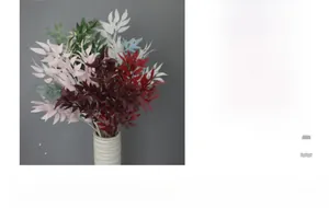 Artificial willow leaves in multiple colors arranged in a modern white ceramic vase