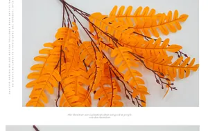 Detail of orange artificial fern leaves with serrated edges and realistic branch texture