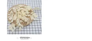 Detail of five-forked artificial peanut leaves in champagne color on a woven mat