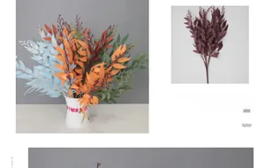 Detail of colorful artificial willow leaves in a white woven vase with pink ribbon