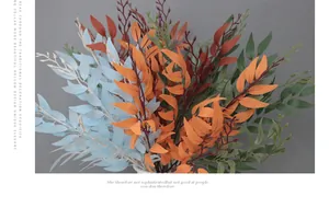 Close-up of artificial willow leaves in blue, orange, red and green for floral decor