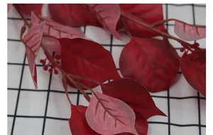 Macro detail of artificial red leaves and berries with realistic texture and veins