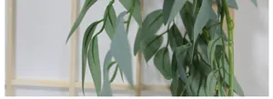 Close-up of realistic grey-green artificial willow vine foliage on a wooden grid