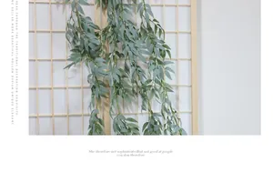 Detail of hanging artificial willow leaves against a wooden lattice for home decor