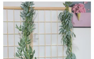 Close-up of artificial willow vine hanging on wooden trellis for indoor home decoration