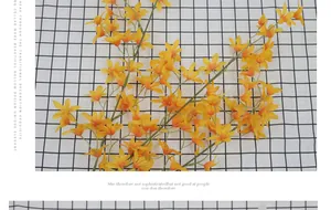Detailed top view of vibrant yellow artificial Dancing Orchid bouquet on checkered fabric