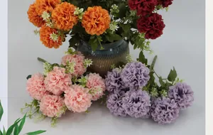 Macro view of multi-color artificial dahlia bouquets with green leaves in a ceramic vase