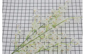 Detailed view of white artificial Oncidium orchid petals with orange centers and green stems