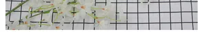 Detail of white artificial orchid petals with yellow stamens on checkered fabric background