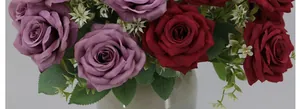 Detail view of artificial Austin roses in deep purple and dark red within a grey vase