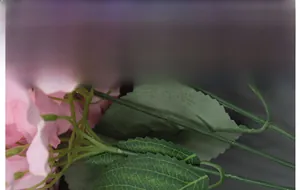 Detail of pink silk hydrangea petals with realistic green leaf texture and stems