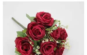 Vista detallada de rosas artificiales rojo oscuro con pétalos de seda y hojas verdes