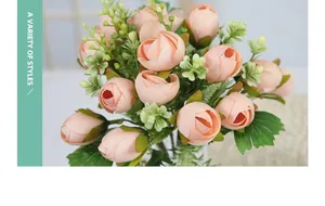 Close-up of pink silk mini tea rose buds with green leaves and small white flowers