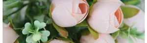 Macro shot of artificial mini tea rose buds in soft pink silk with realistic green leaves
