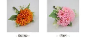 Detail view of artificial African daisies in orange and pink with lush green leaves