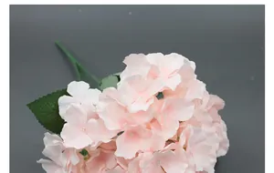 Close-up of artificial light pink hydrangea bunch with green leaves for home decor