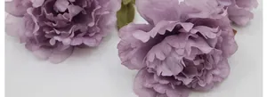 Macro view of light purple faux peony petals with realistic textures and green leaves