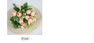 Top view of mini pink artificial tea rose bouquet on a woven mat background