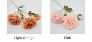 Detail view of artificial silk peonies in light orange and pink with green leaves
