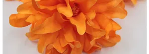 Primer plano de dalia de seda naranja con textura de tela realista y diseño en capas