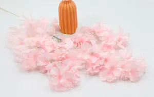 Detalle de flores de cerezo rosa artificiales con pétalos texturizados y tallos finos
