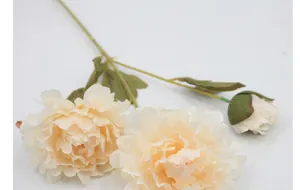 Detail of artificial light orange peony with two silk flower heads and a small bud