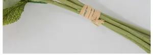 Close-up of artificial sunflower stems tied with rustic beige raffia rope detail
