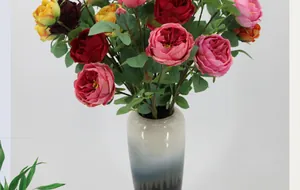 Detailopname van meerkleurige kunstmatige Austin-rozen in een moderne keramische vaas