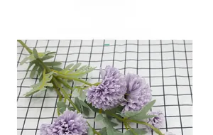Detailed view of artificial purple silk dandelion flower on checkered fabric background