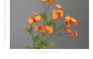 Nahaufnahme künstlicher orangefarbener Gänseblümchen mit realistischen Blättern