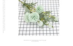 Detail view of mint green silk dandelion onion ball flowers on a checkered cloth