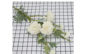 Detail of white artificial pompon flowers with realistic green stems and lush leaves