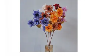Close-up of multi-colored silk dahlia and chrysanthemum flowers in a ribbed glass vase
