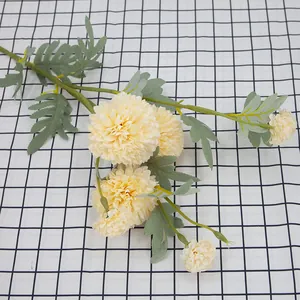 Artificial cream dandelion bouquet with six flower heads and green leaves on a grid background