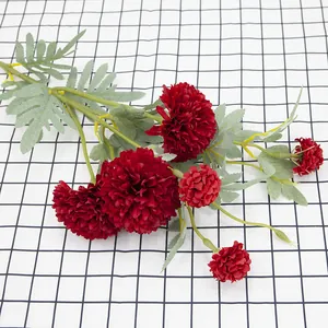 Artificial red dandelion flower bouquet with lush petals on a checkered background