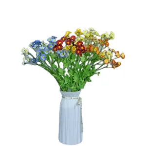 Künstliche Kamille und Gänseblümchen in weißer Keramikvase für die Heimdekoration