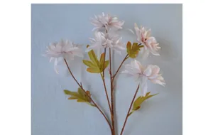 Close-up of five-headed artificial dahlia flowers in soft pink on a blue fabric background