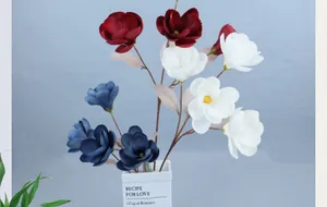 Detailed view of artificial magnolia flowers in red, white and blue in a white vase