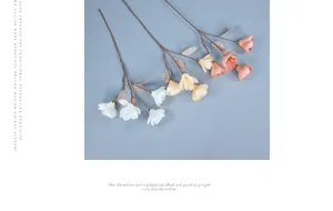Detailed view of artificial magnolia branches in white, yellow and pink on blue background