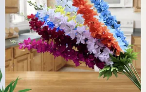 Vue détaillée de fleurs de delphinium artificielles colorées sur une table en bois